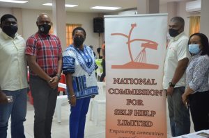 Minister Beckles takes a photo with officers from the National Commission for Self-Help Ltd before the start of the Outreach Caravan in Blanchisseuse last Saturday hosted by the Ministry of Housing and Urban Development.